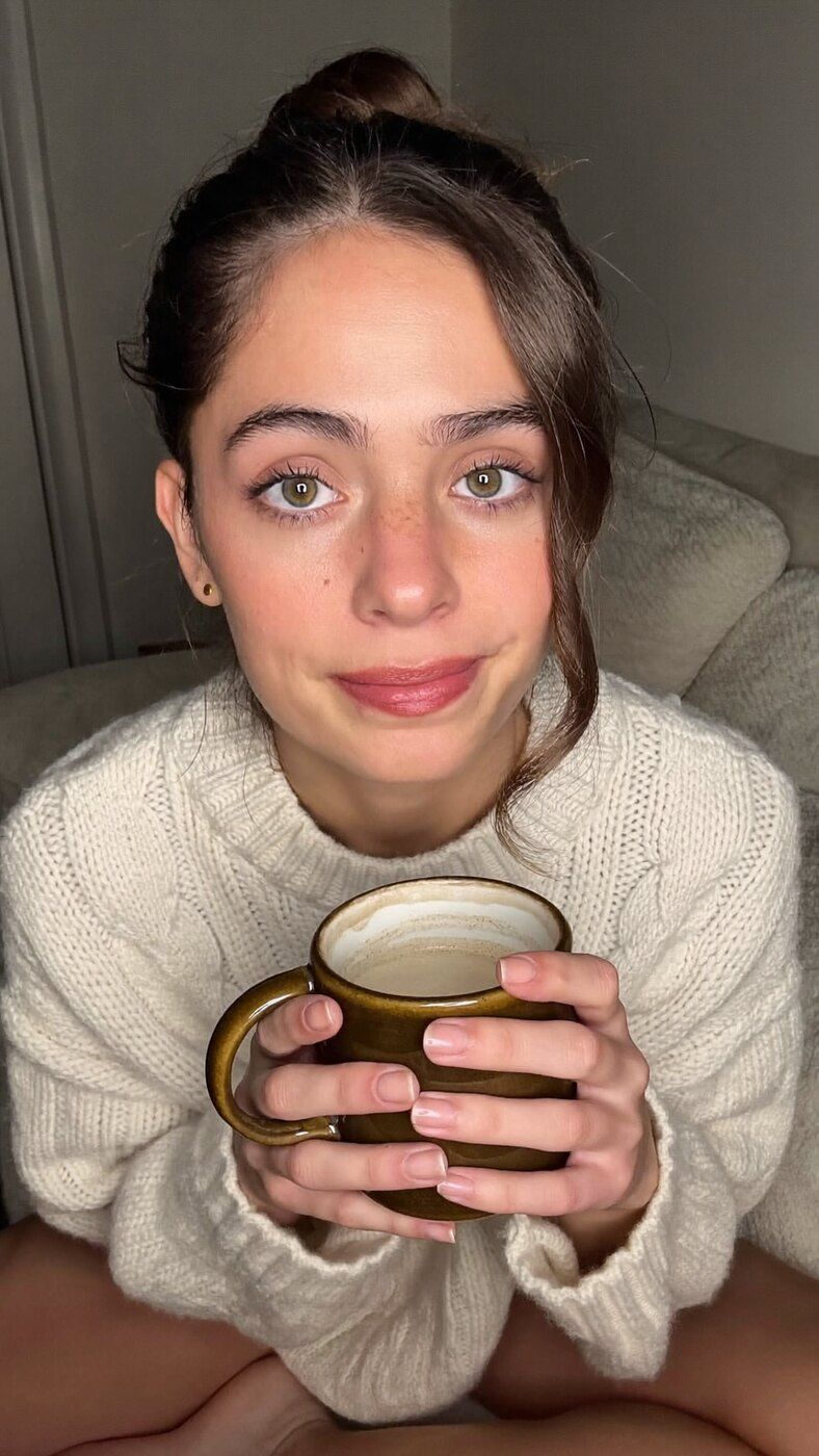 Nora Lind in a cream knit sweater, looking straight into the camera